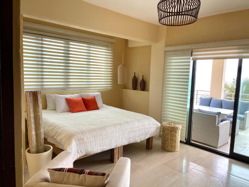 1 dormitorio con 1 cama con almohadas de color naranja en SeArena San Pancho en San Francisco