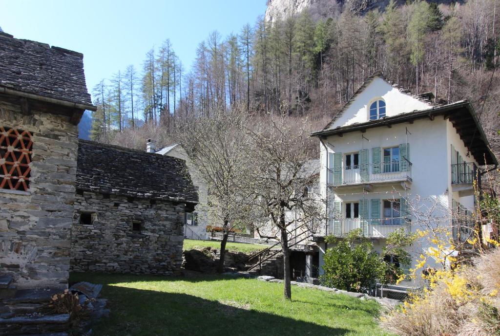 un edificio blanco en un patio junto a una casa en Casa Eva, en Brione