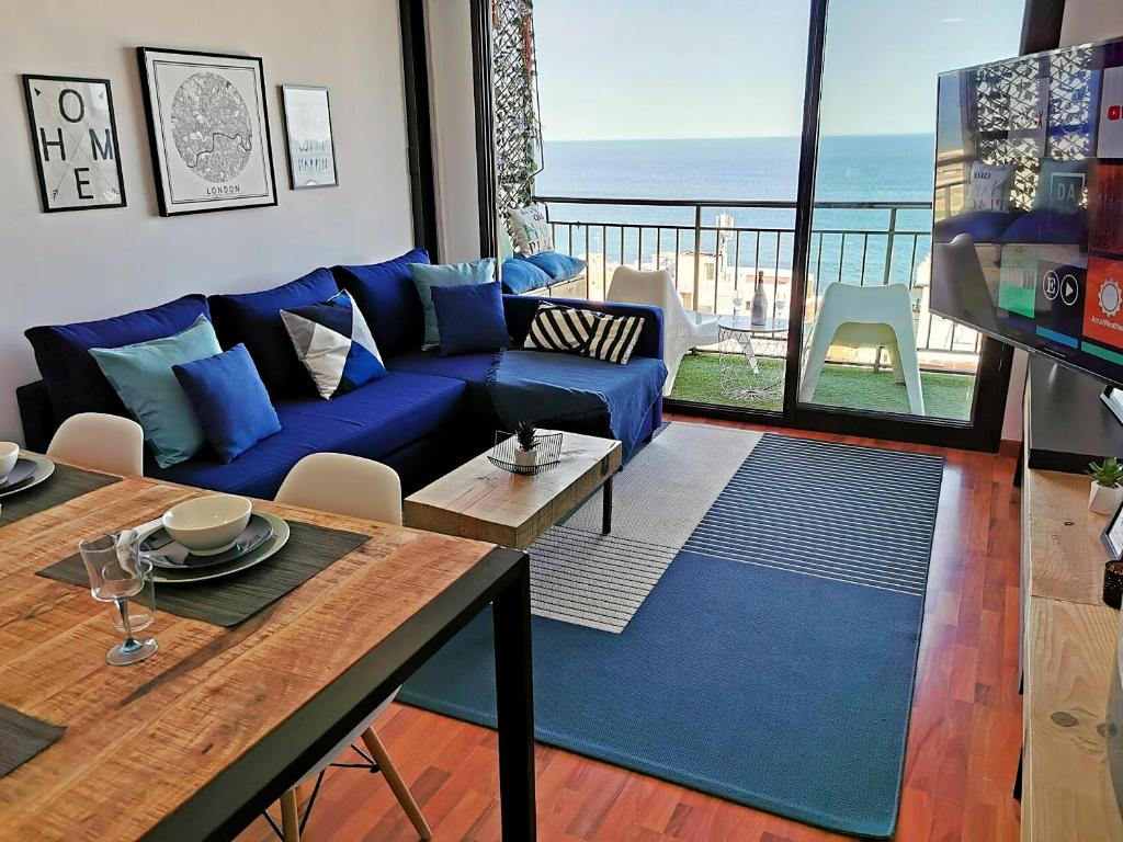 a living room with a blue couch and a table at Golden Blue Arenales in Arenales del Sol