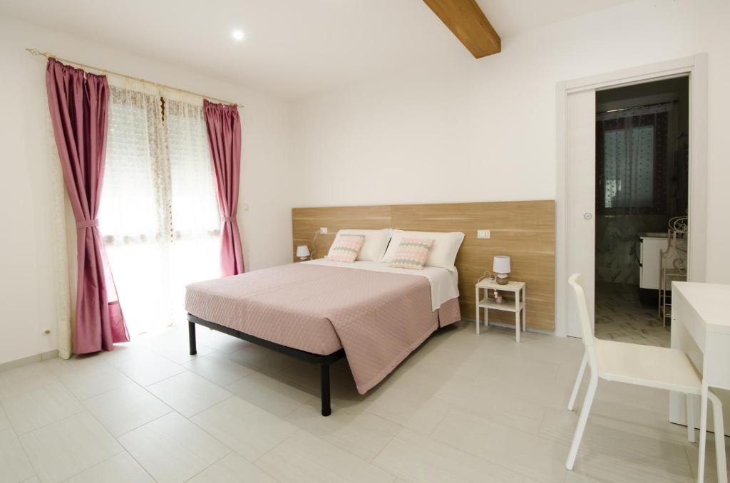 a white bedroom with a bed and a bathroom at B&b la Casa dei Nonni in Silvi Paese