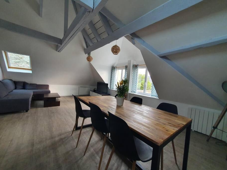 uma sala de estar com uma mesa de madeira e cadeiras em Charmant appartement proche commerces et plages em Le Guilvinec