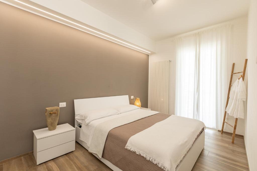 1 dormitorio con cama blanca y ventana en Appartamento L'Essenziale, en Vieste