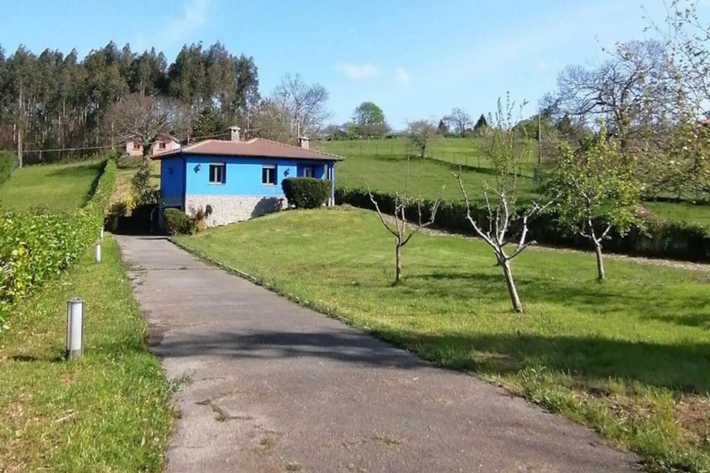 a blue house in a field next to a road at La casa azul de Lua Un lugar mágico in Juncedo-Campo