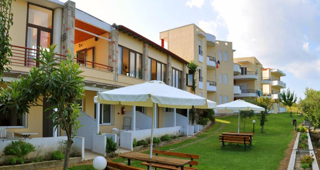 a row of buildings with benches and umbrellas at Adonis in Kallithea Halkidikis