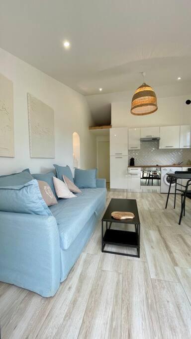 un salon avec un canapé bleu et une table dans l'établissement Maisonnette chaleureuse a proximité du centre, à Narbonne