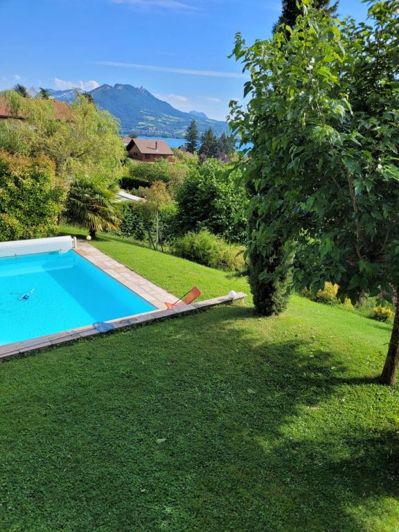 een tuin met een zwembad en een boom bij Beautiful property in front of Annecy Lake in Veyrier-du-Lac