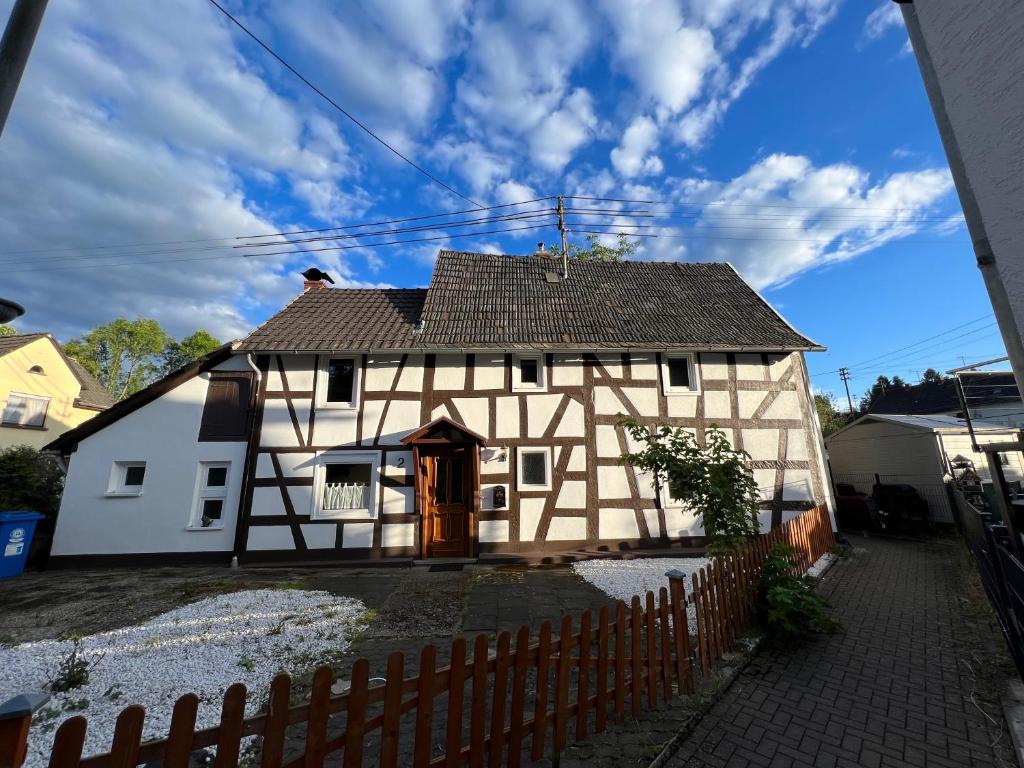 a white house with a fence in front of it at 300 Jahre altes renoviertes Fachwerkhaus in Peterslahr