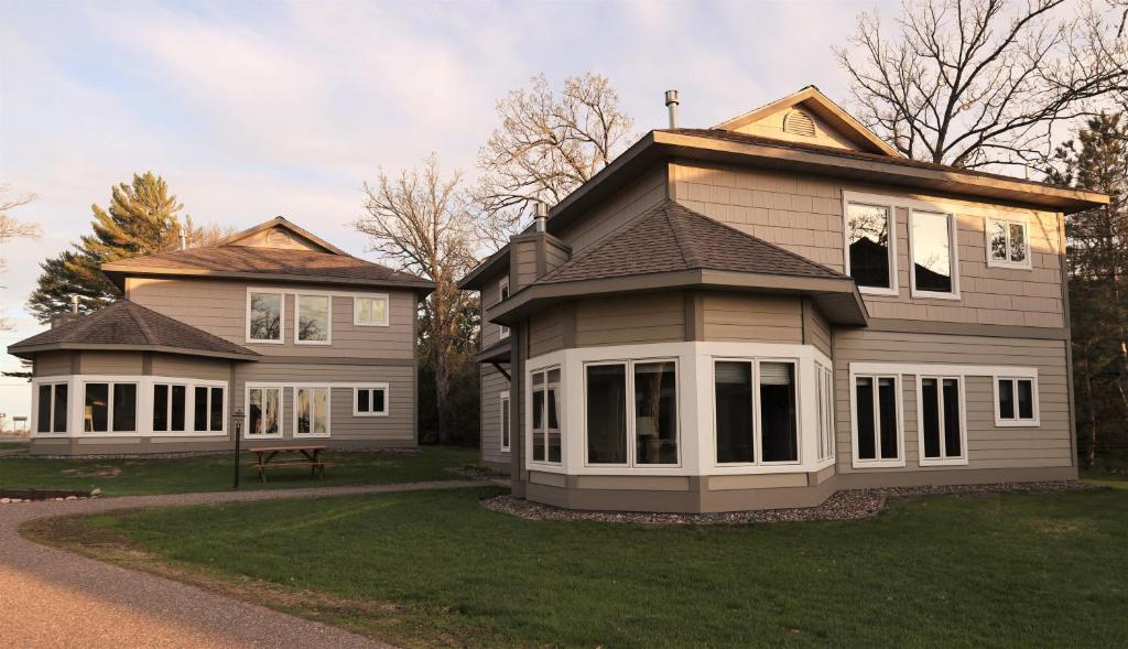 ein Haus mit einer Veranda und einem Haus mit einem Tisch in der Unterkunft Bay Colony 762 - Lower in Nisswa