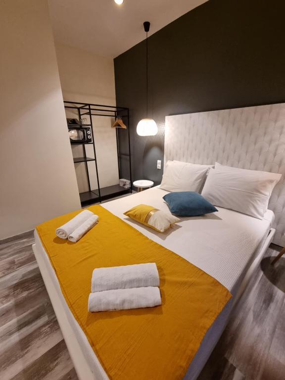 a bedroom with a large bed with two towels on it at City Space Suites in Giannitsa