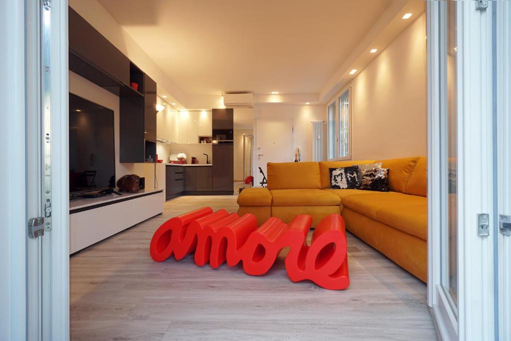 a living room with a yellow couch and red objects at Ghisello Luxury Guesthouse in Bologna