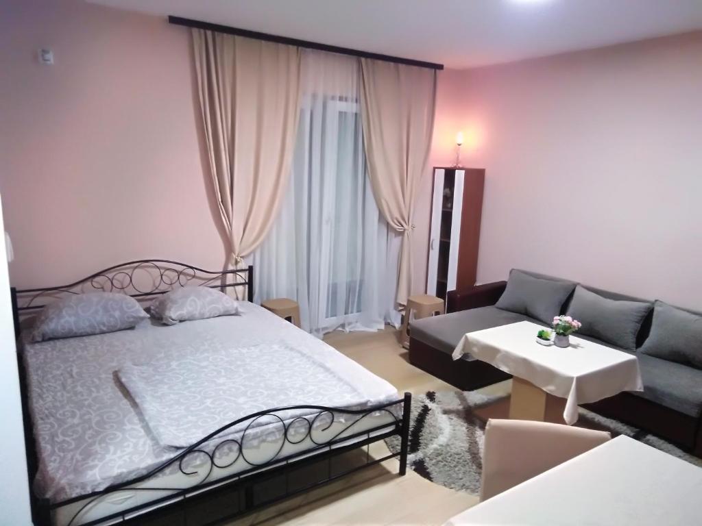 ein Schlafzimmer mit einem Bett und einem Sofa in der Unterkunft Apartman 1 in Vrnjačka Banja