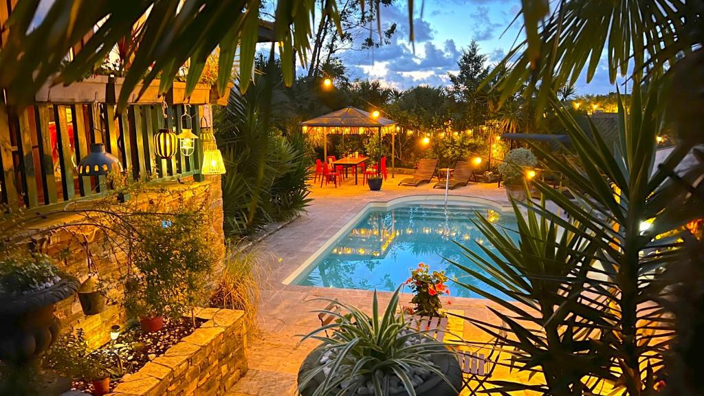 un patio trasero con piscina por la noche en Villa Merkel - 25 pers - 10 chambr - 9 WC - Piscine, en Anglet