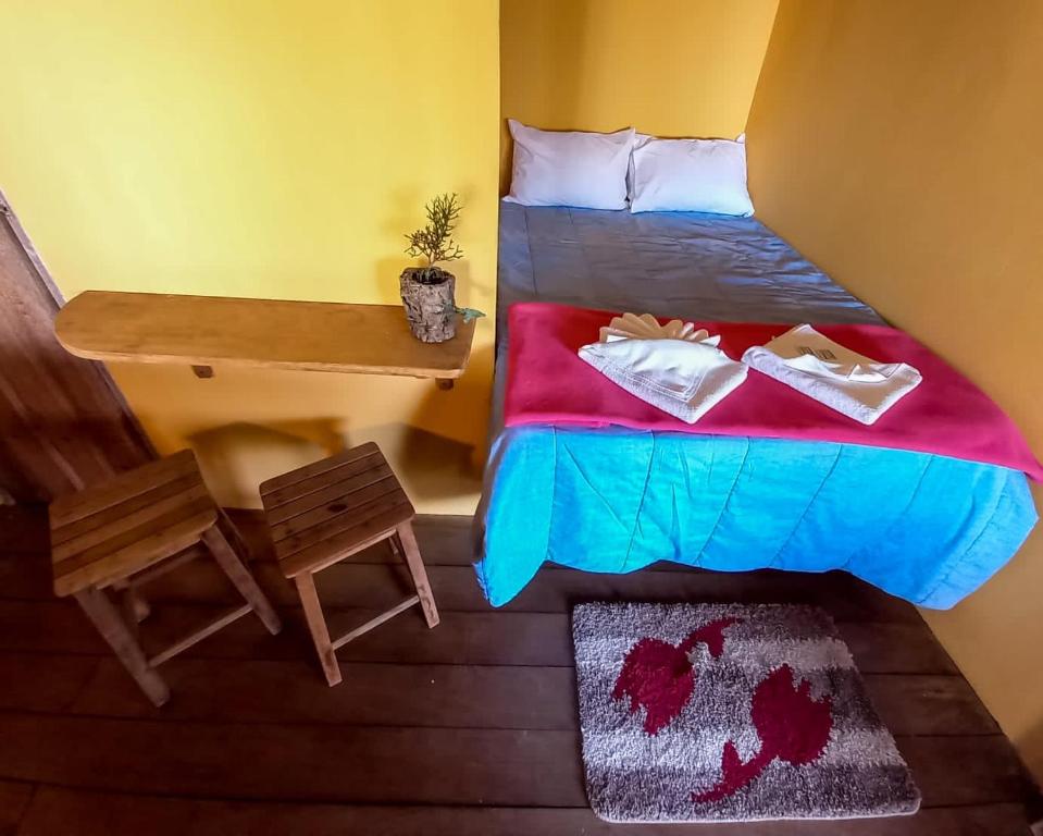 a small bedroom with a bed and a desk at BITUCA HOSTEL CAFÉ in Milho Verde