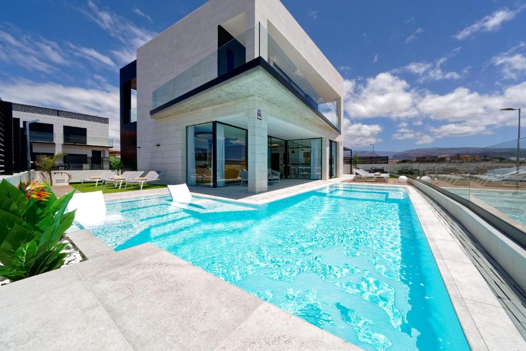 a swimming pool in front of a house at Villa Sant Meloneras in Meloneras