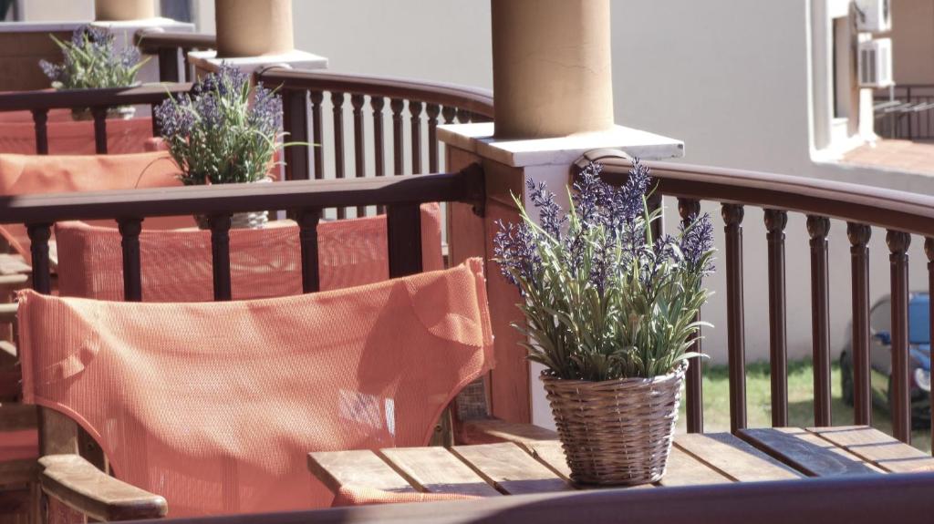 a table and chairs on a balcony with purple flowers at House Chrysoula Mitsokopi in Sarti