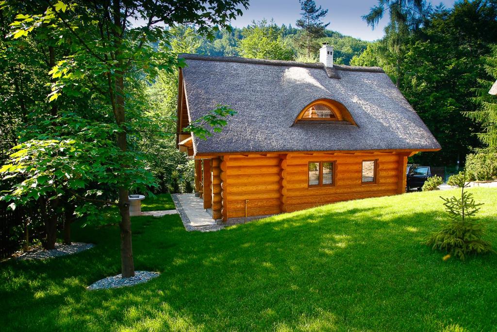 a log cabin in a yard with a tree at Dom z Bali MARS in Międzybrodzie Żywieckie