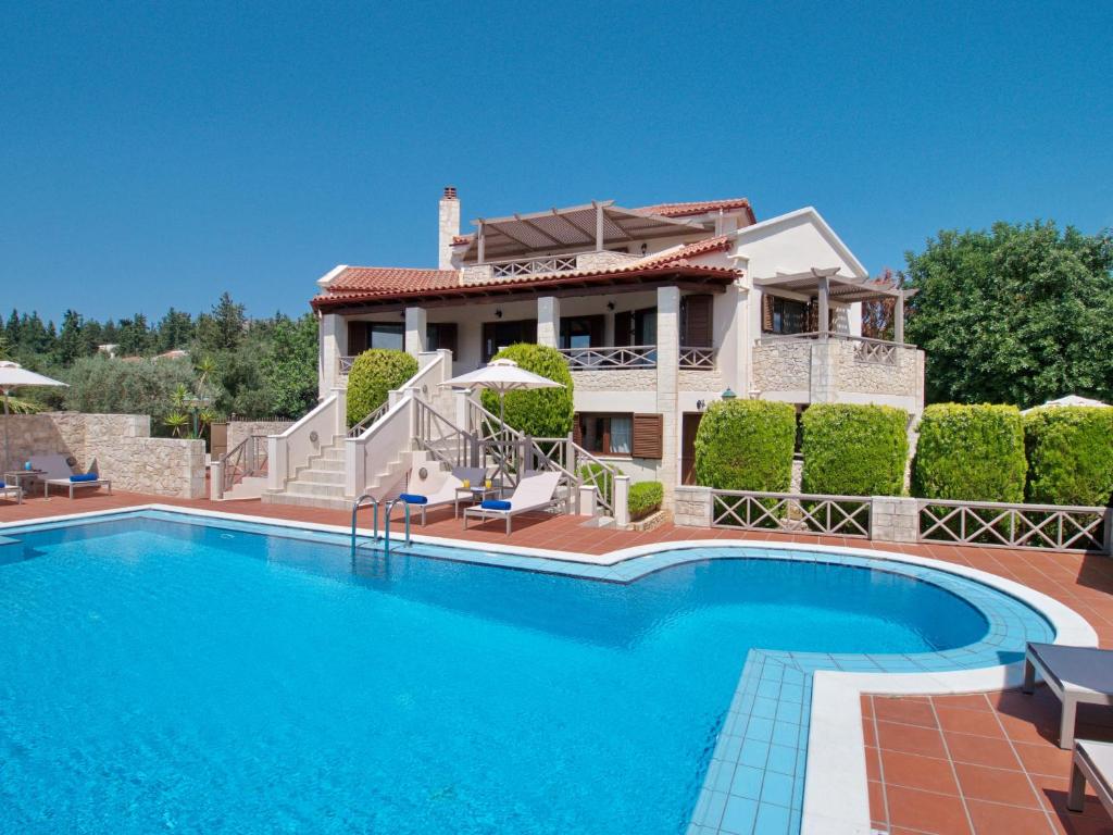 uma villa com piscina em frente a uma casa em Villa Metapothia Gavalochori Crete em Gavalochori