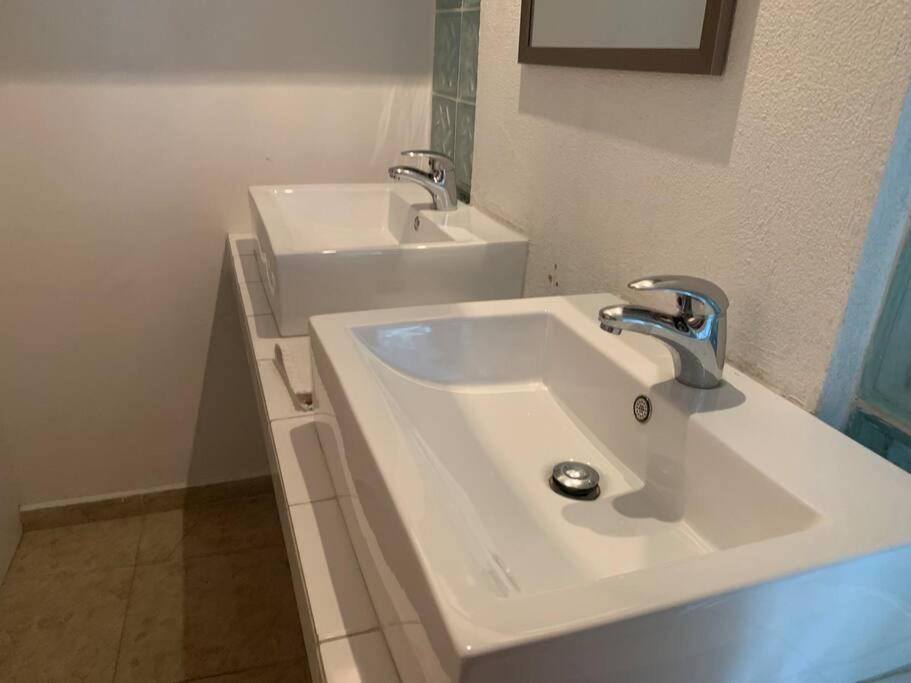 Baño blanco con lavabo y espejo en Hermoso Loft espectacular vista BosquesdelasLomas, en Ciudad de México