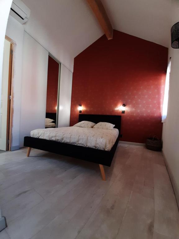 - une chambre dotée d'un lit avec un mur rouge dans l'établissement Laetitia et Yaniv Dagon, à Elne