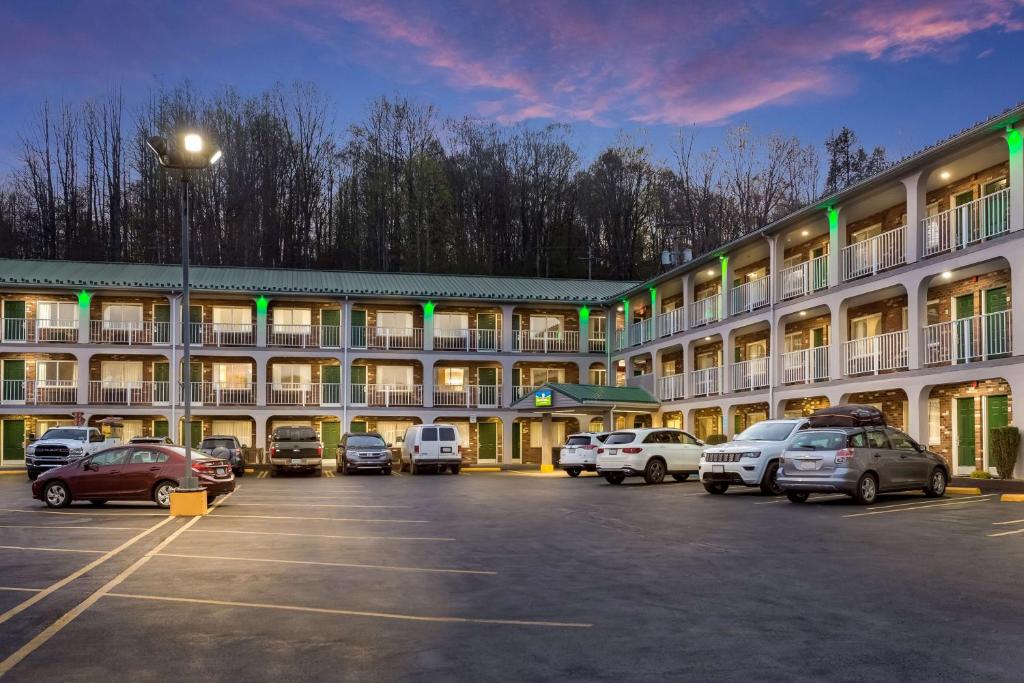 un gran edificio con coches estacionados en un estacionamiento en SureStay Hotel by Best Western Summersville, en Summersville