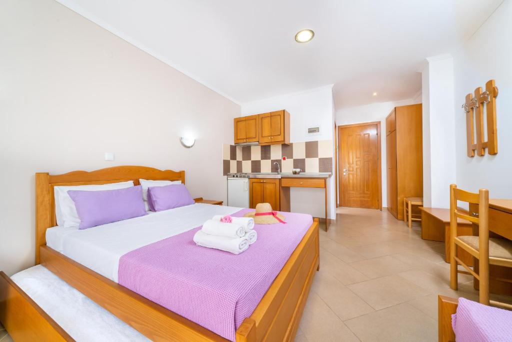 - une chambre avec un grand lit et des oreillers violets dans l'établissement Aperito Studios, à Potos