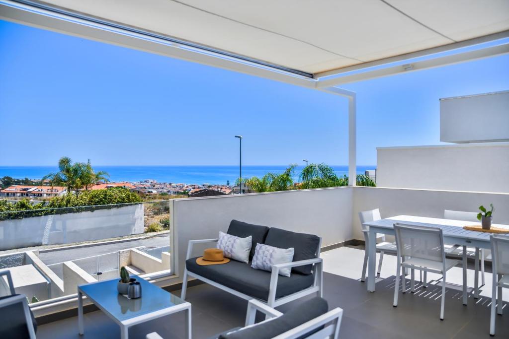 a room with a balcony with a table and chairs at Casa Blanca Sea View in Marina di Ragusa
