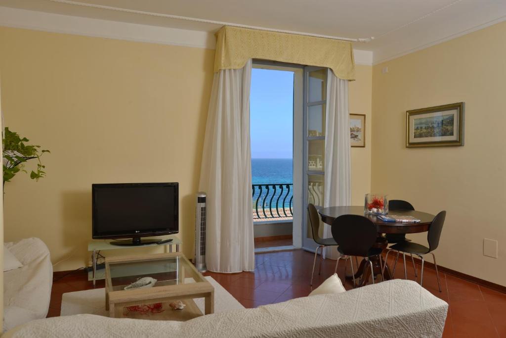 a living room with a television and a view of the ocean at Casa Alice in Alghero