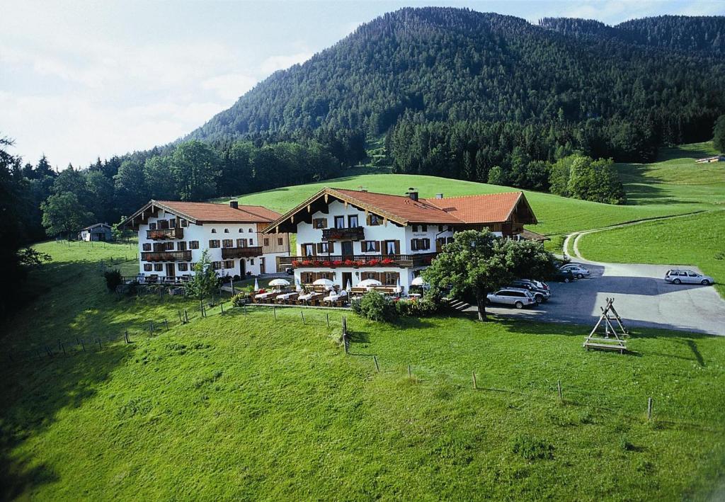 an aerial view of a house in a green field at Berggasthaus Weingarten in Ruhpolding