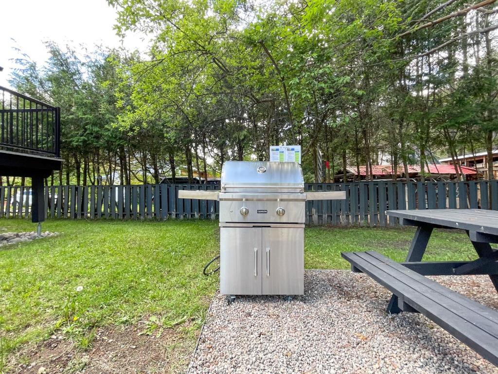 a grill in a park next to a picnic table at Complexe LIVTremblant by Gestion ELITE - LIV6 in Mont-Tremblant
