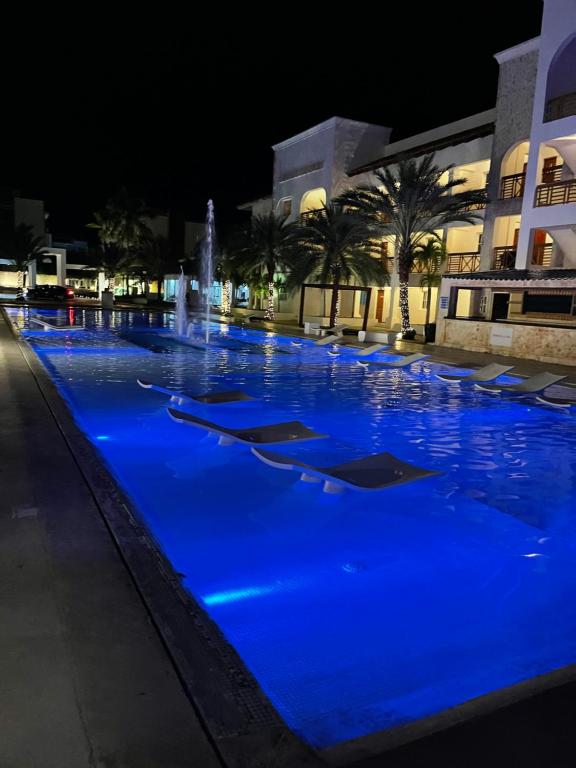 una piscina con iluminación azul por la noche en Espectacular Apartamento En Tanama Cap Cana en Punta Cana