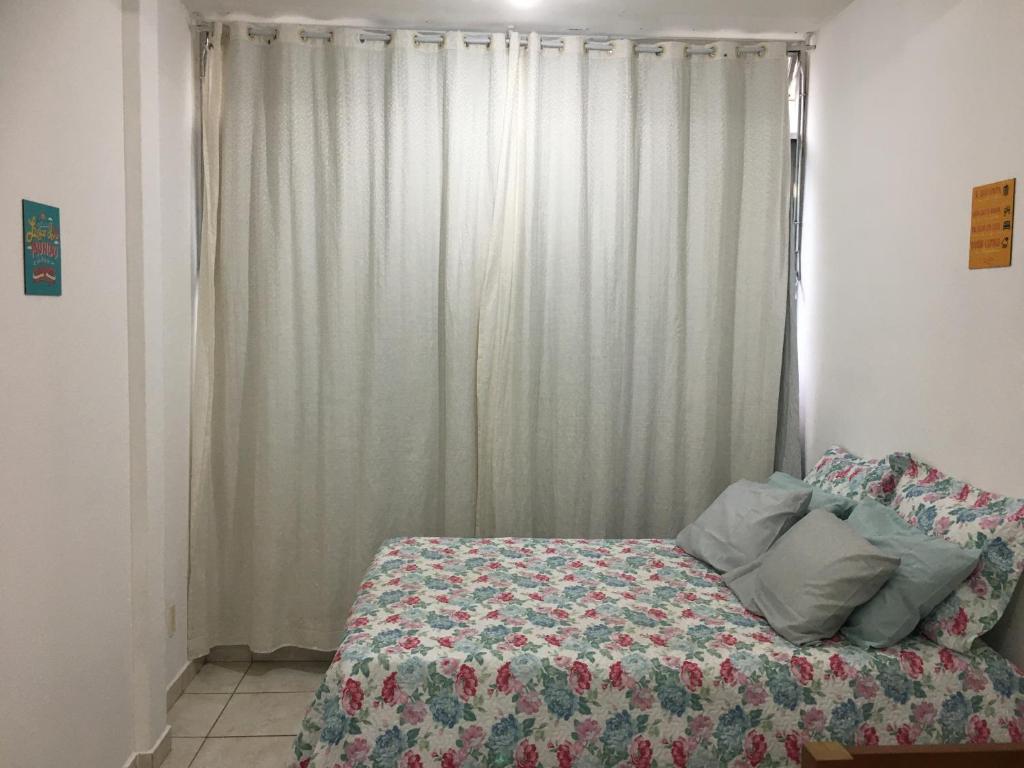 a bedroom with a bed and a window with curtains at Meu Apartamento a 15min de Copacabana in Rio de Janeiro