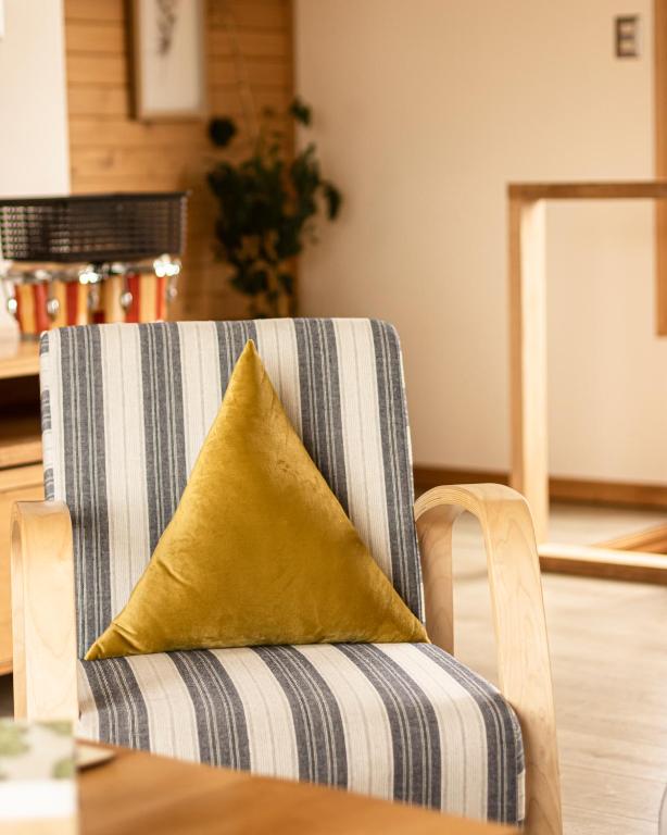 a yellow pillow on a chair with a table at Cabañas Arrayanes de Huillinco en Chiloé in Chonchi