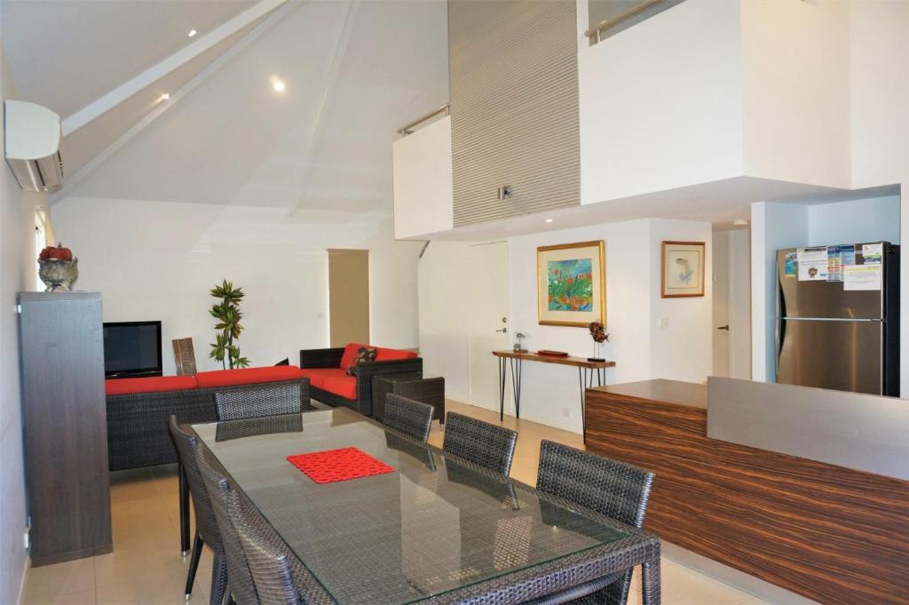 a dining room and living room with a glass table at Osprey Holiday Village Unit 104 in Exmouth