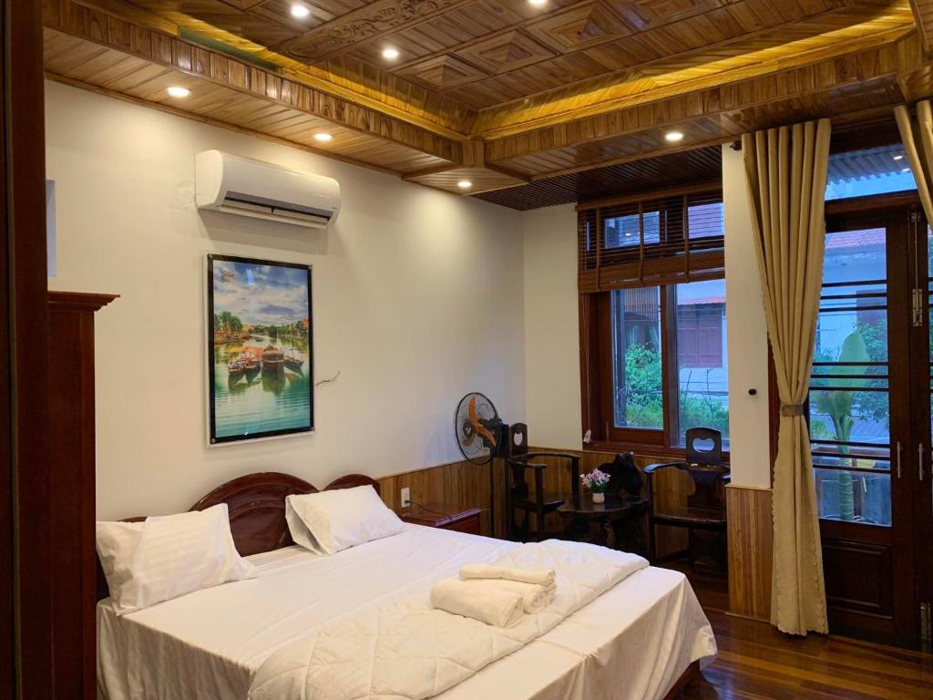 a bedroom with a large bed with white sheets at Phố Seoul Homestay And Spa in Hoi An