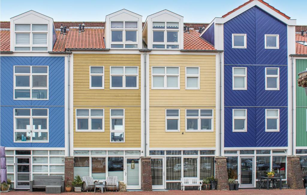 una fila de casas de color azul y amarillo en 2 Bedroom Beautiful Home In Hellevoetsluis en Hellevoetsluis