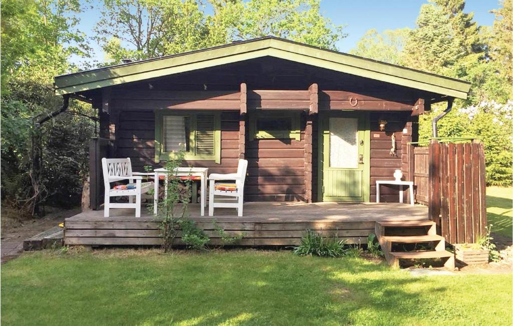 a cabin with a table and chairs on a deck at 2 Bedroom Stunning Home In rkelljunga in Fasalt