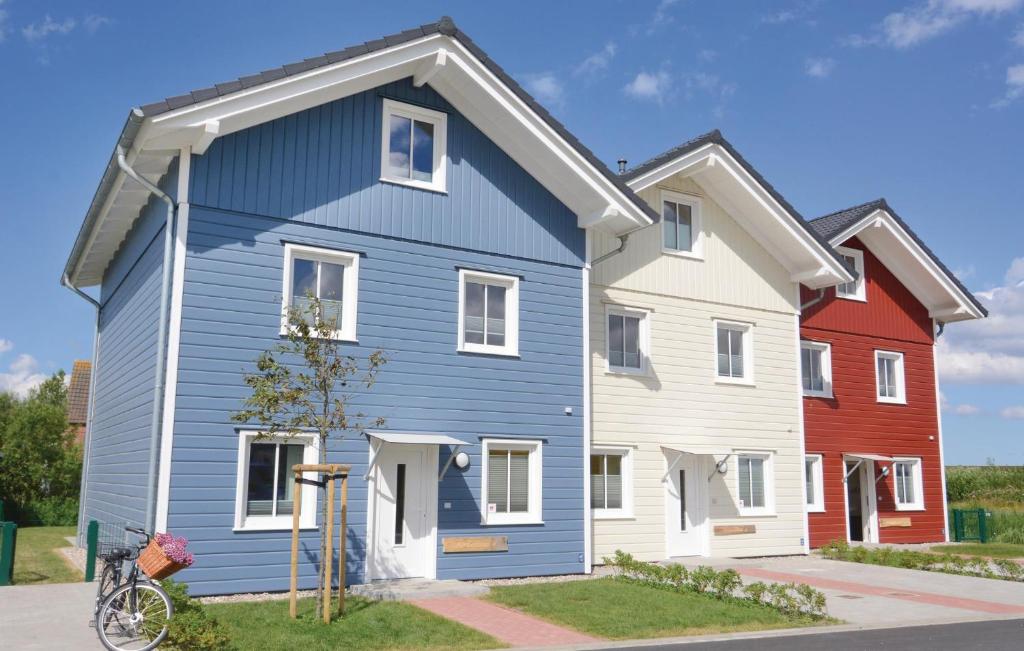 uma casa azul com uma casa vermelha e branca em Gorgeous Home In Dagebll With Wifi em Dagebüll