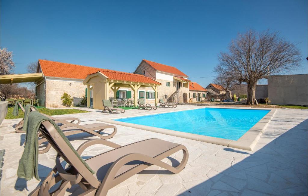 una piscina con due sedie a sdraio accanto a una casa di Beautiful Home In Ljubotic With Outdoor Swimmin,,, a Ljubotic