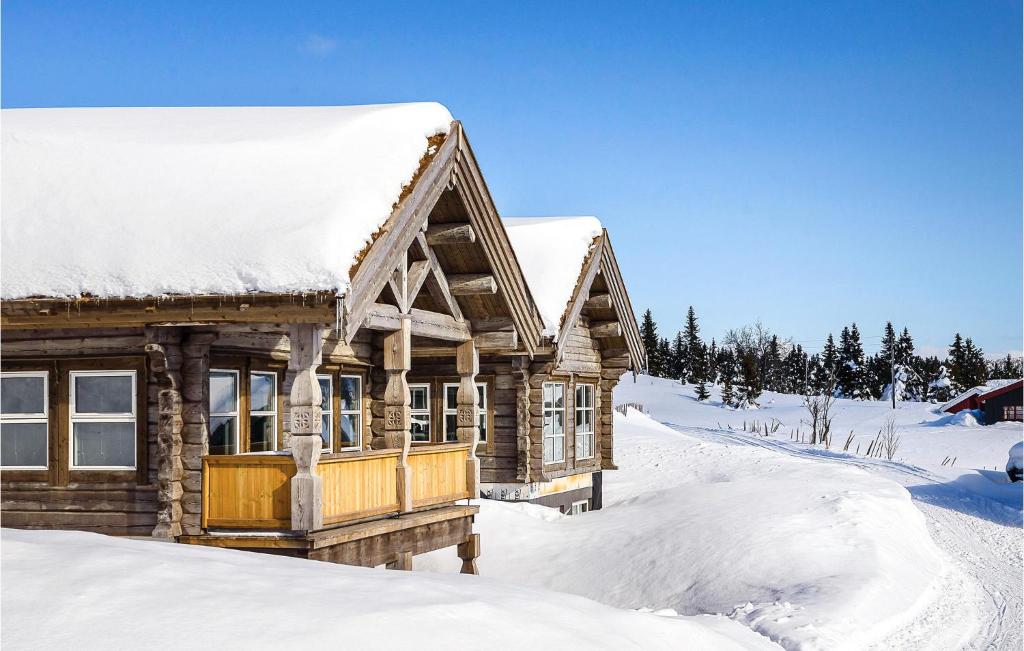 una cabaña de madera en la nieve en Gorgeous Home In Sjusjen With Sauna en Sjusjøen