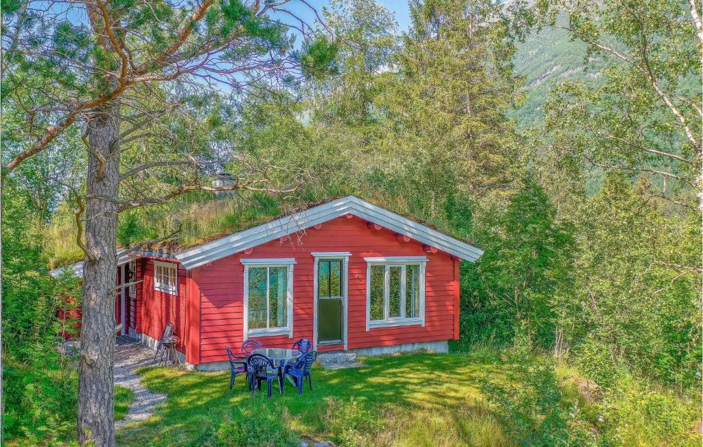 a red cabin with a table and chairs in front of it at Awesome Home In Olden With 3 Bedrooms, Sauna And Wifi in Olden