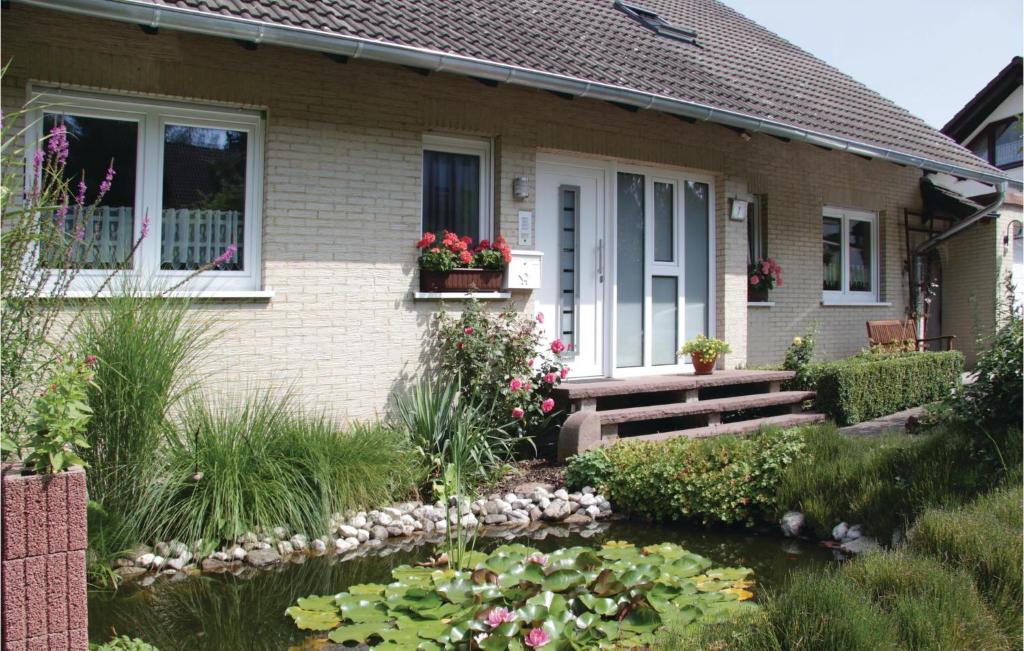 een huis met een vijver ervoor bij 2 Bedroom Nice Apartment In Wesertal-gieselwerder in Gewissenruh