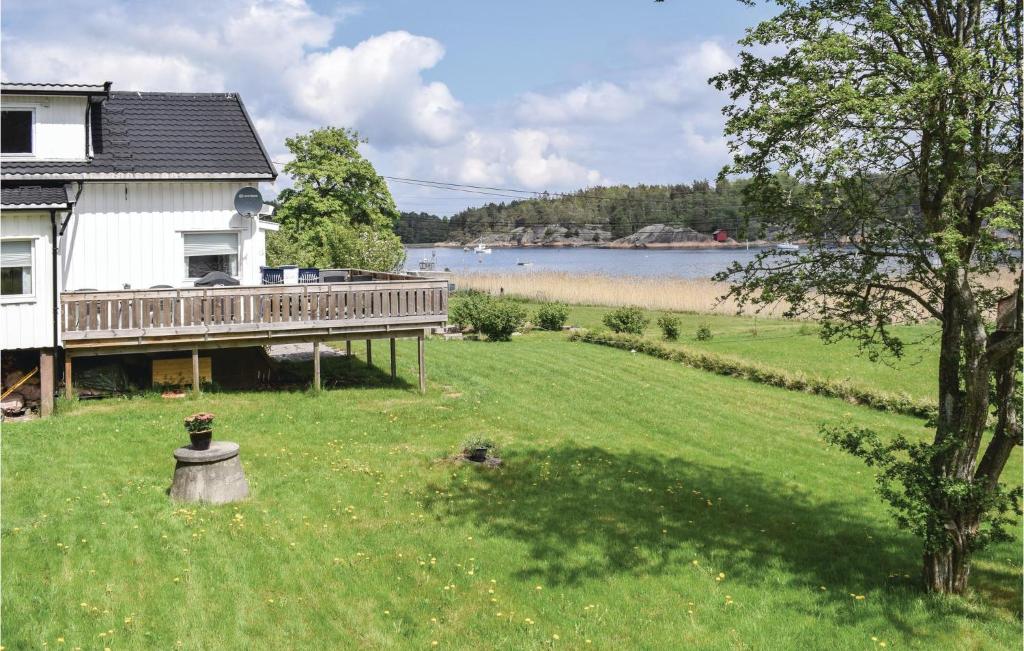 a house with a deck next to a lake at Amazing Home In Vestery With Kitchen in Hauge