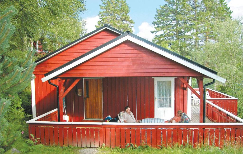 ein rotes Haus mit zwei Leuten auf einer Veranda in der Unterkunft Amazing Home In Sandvoll With 3 Bedrooms And Internet in Sandvoll