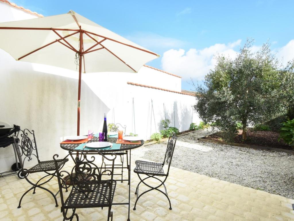 patio con tavolo, sedie e ombrellone di Maison Ars-en-Ré, 5 pièces, 9 personnes - FR-1-258-83 ad Ars-en-Ré