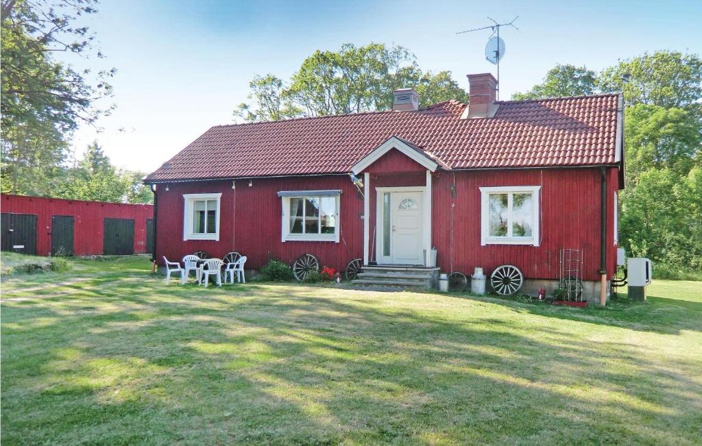 a red house with a white door on a yard at Beautiful Home In Rockneby With Kitchen in Slakmöre Strand