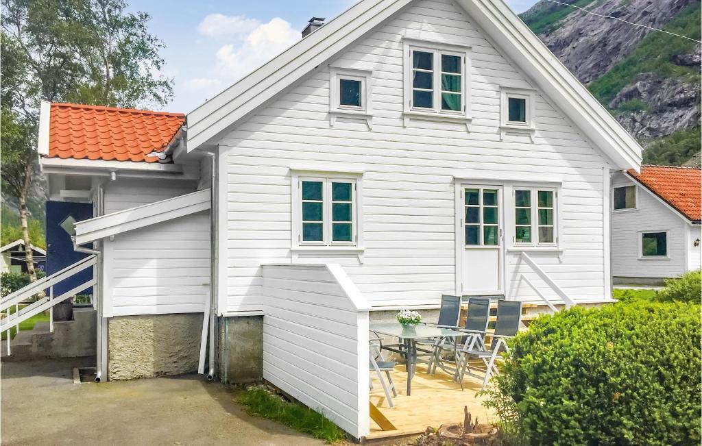 een wit huis met een tafel en stoelen bij Gorgeous Home In Dirdal With House A Mountain View in Dirdal