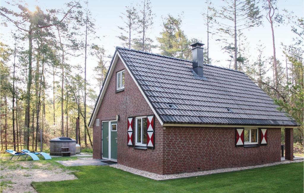een rood bakstenen huis met een grill in een tuin bij Vossenhol in Ommen