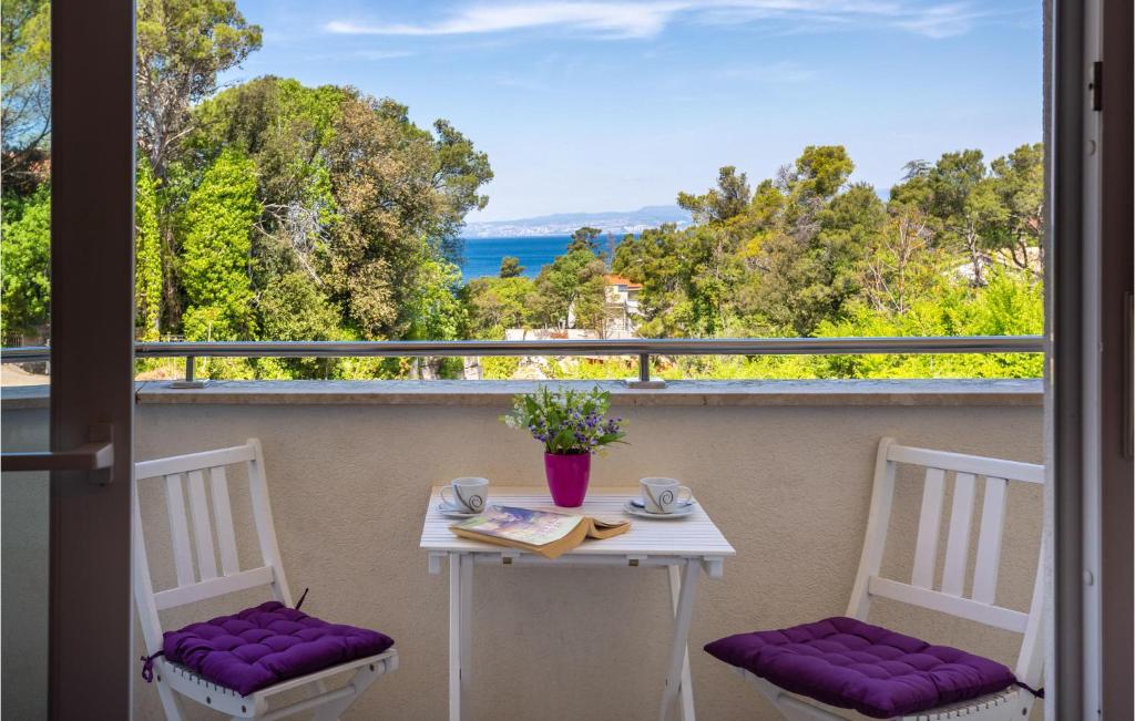 uma mesa e cadeiras numa varanda com vista para o oceano em Lovely Apartment In Malinska With Wifi em Malinska