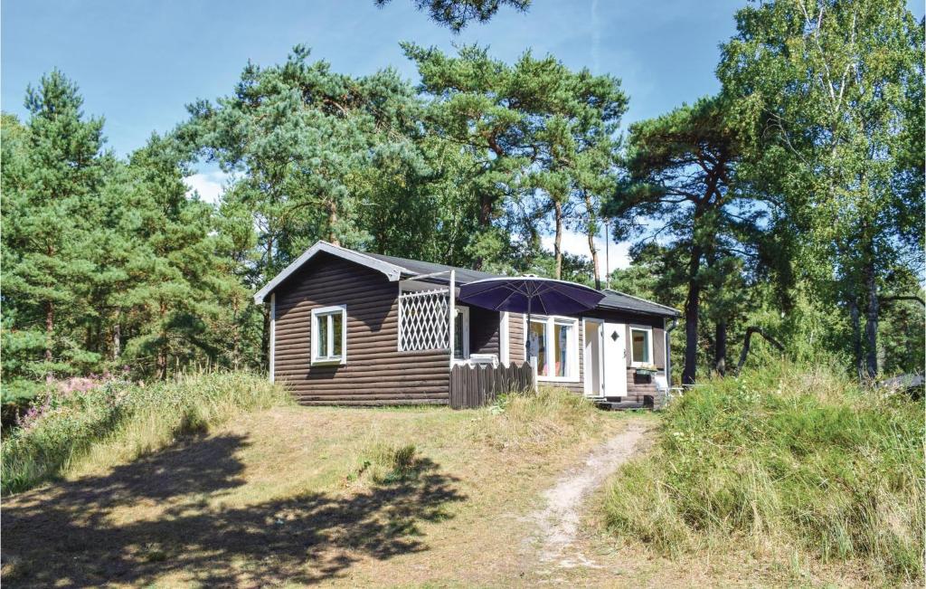 eine kleine Hütte mit einem Regenschirm auf einem Feld in der Unterkunft 2 Bedroom Stunning Home In Lderup in Löderup