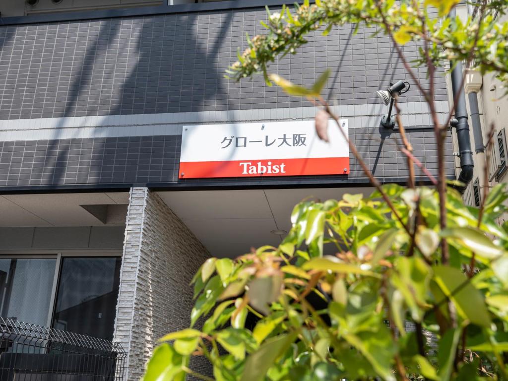 una señal en el lateral de un edificio en Tabist Gloire Osaka en Osaka
